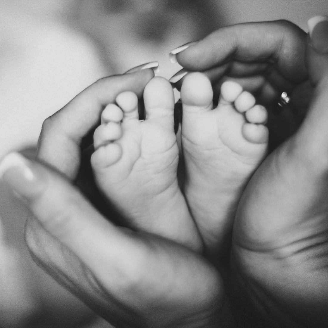 Mother holding babies feet.